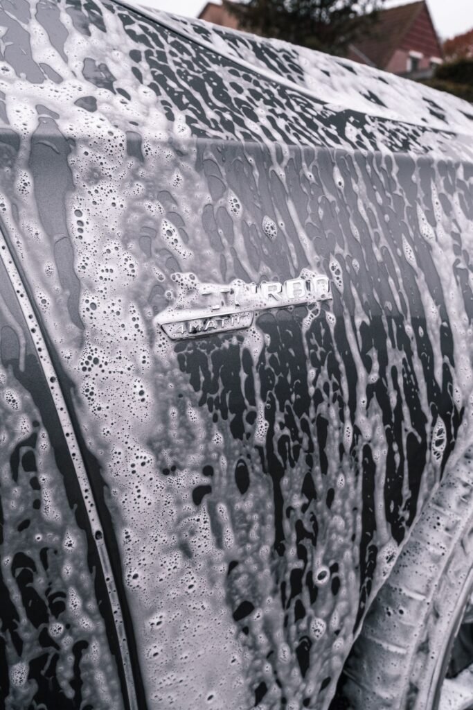 Close-up van een auto onder een laag schuim tijdens het wassen